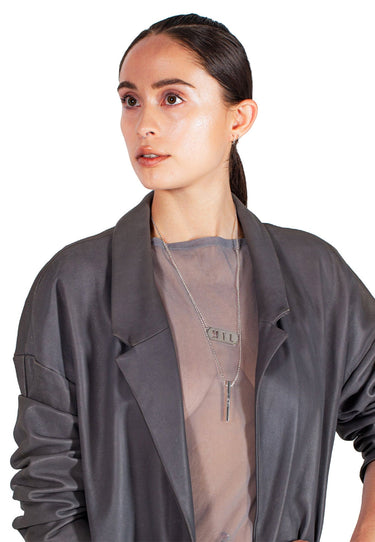 Model wearing silver Beacon necklace with engraved pendant and layered chains, unisex stainless steel streetwear jewelry by MYL BERLIN